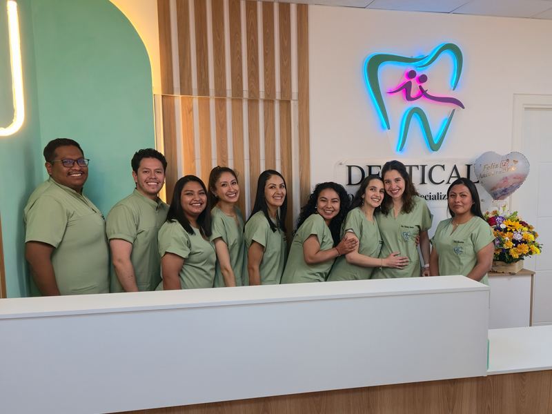 El equipo de Dentical en la recepción de la clínica, bajo el logo en neón.